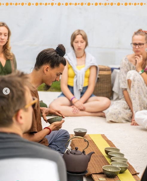 Group of people in a community tent participating in a collective event, likely a social gathering or event, with a focus ...